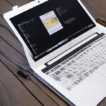 a sleek, modern laptop on a wooden desk, its chassis illuminated by a subtle blue glow from the integrated NPU chip, a translucent overlay shows a 3D neural network graph with nodes and edges pulsing in real time, the laptop’s screen displays a hi…