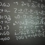 Mathematiker schreibt Primzahlen an Tafel, während digitale Überlagerung großer Primzahlen und modularer Gleichungen leuchtet; feiner Kreidestaub betont die präzisen Striche.