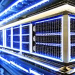 Ein hyperrealistischer Nahaufnahme eines futuristischen Serverracks mit blauem Schein, das die fortschrittliche neuronale Architektur hinter GPT-5 symbolisiert. Die metallischen Oberflächen und fliegenden Staubpartikel unterstreichen die Effizienz…