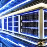 Ein hyperrealistischer Nahaufnahme eines futuristischen Serverracks mit blauem Schein, das die fortschrittliche neuronale Architektur hinter GPT-5 symbolisiert. Die metallischen Oberflächen und fliegenden Staubpartikel unterstreichen die Effizienz…