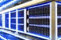 Ein hyperrealistischer Nahaufnahme eines futuristischen Serverracks mit blauem Schein, das die fortschrittliche neuronale Architektur hinter GPT-5 symbolisiert. Die metallischen Oberflächen und fliegenden Staubpartikel unterstreichen die Effizienz…