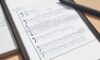 Tablet mit minimalistischer Oberfläche zur Schritt-für-Schritt-Lösung einer quadratischen Gleichung, platziert auf einem professionellen Schreibtisch mit Notizbuch und Kugelschreiber im weichen, natürlichen Licht.